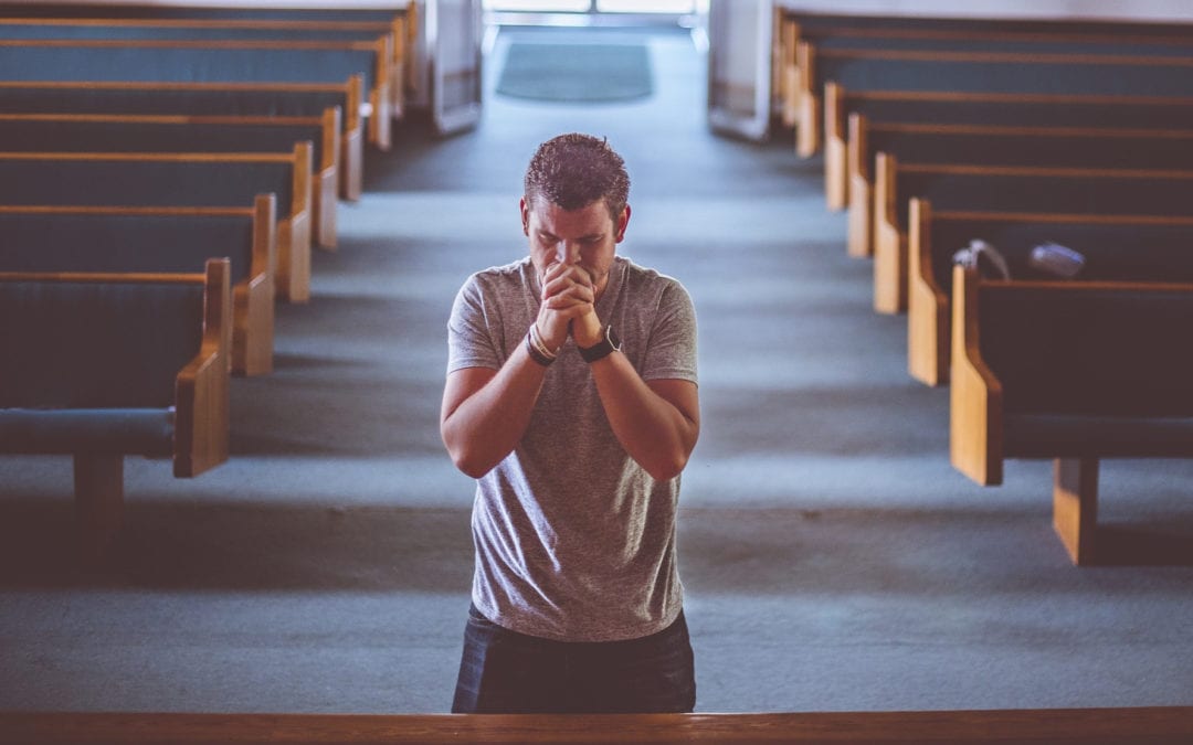 man praying in a church - Hirzel Law